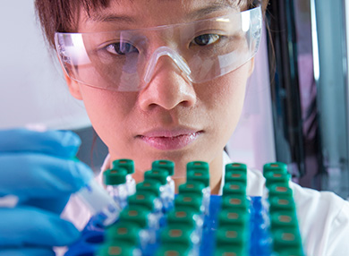 Close-up of a researcher inspecting test tubes in a lab