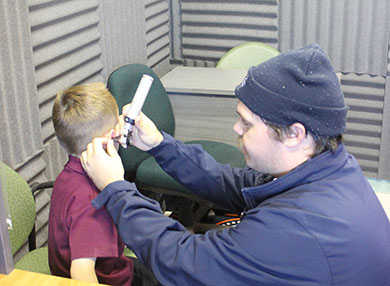 Researcher looking into a child's ear