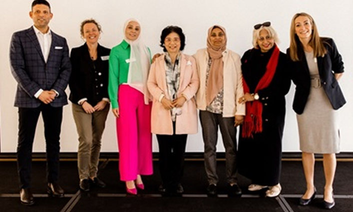 Seven health professionals standing together and smiling.