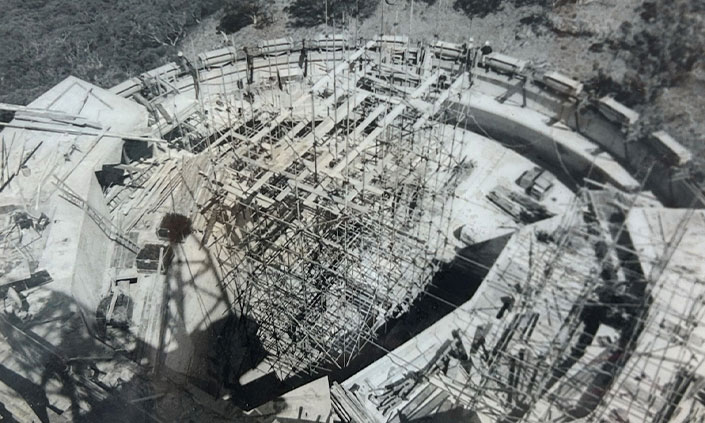 Black and white photo of the construction of the telescope, centre there is scaffolding inside a large concrete circle