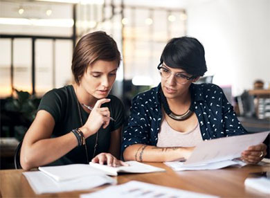 Two women reviewing papers