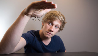 Photo of a student with a spider on his hand