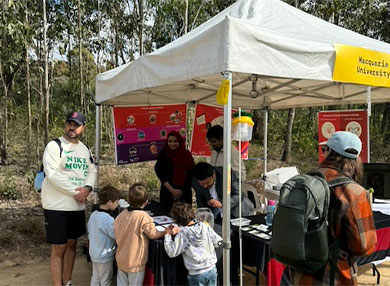 Several children interacting with science demonstration at marquee