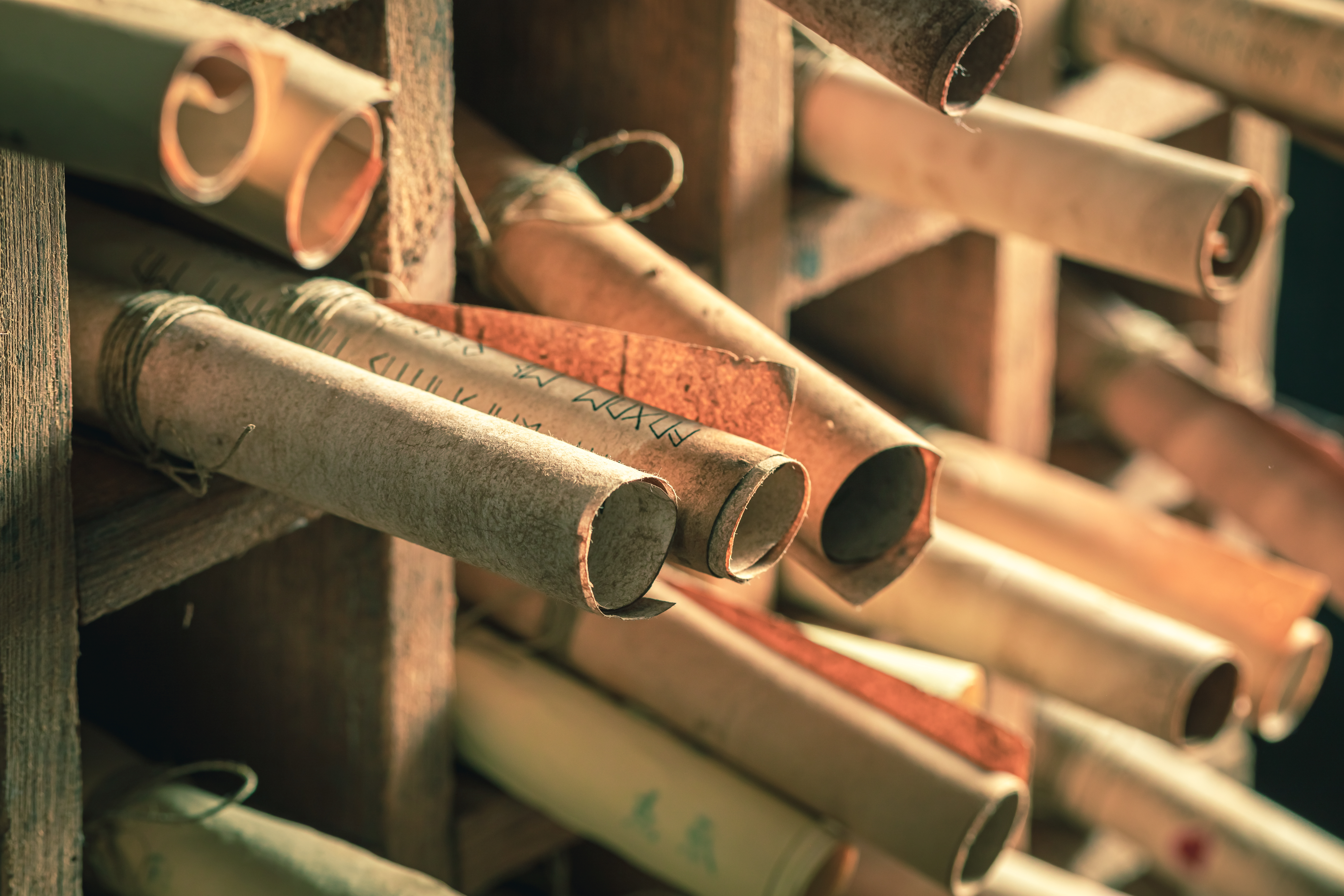 Several paper scrolls lying on a shelf