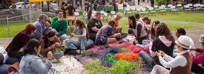 Group of people sitting on the floor interacting with colourful wires