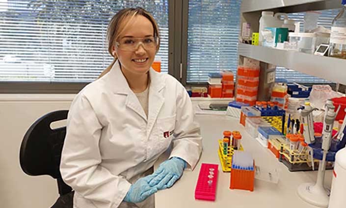 Dr Jennilee Davidson sitting at a desk in a lab