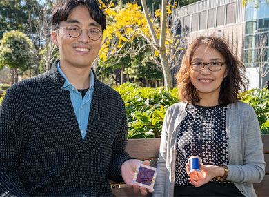Researchers posing holding solar cell