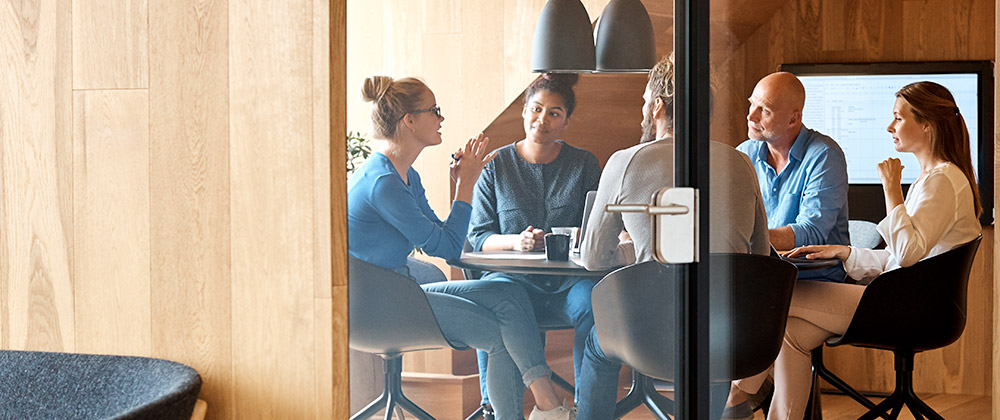 Group of professionals sitting at a meeting table having a chat.