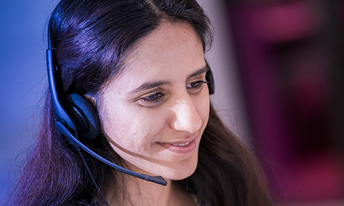 A smiling worker wearing a microphone headset.