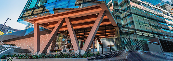 Front facade of building showing gardens beneath the 'W' shaped wooden supporting beams.